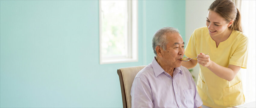 Caregiver feeding senior man palliative care concept with copy space