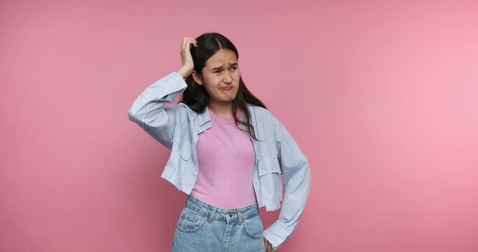 Girl shows different emotions in a studio with pink background at a light moment