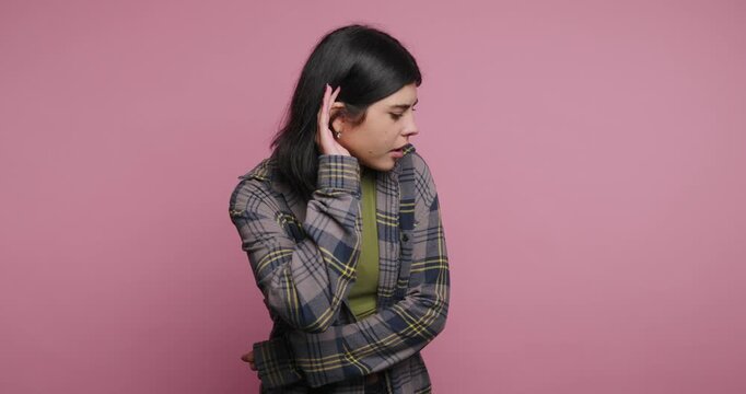 Woman shows different expressions while standing against a pink wall in a room