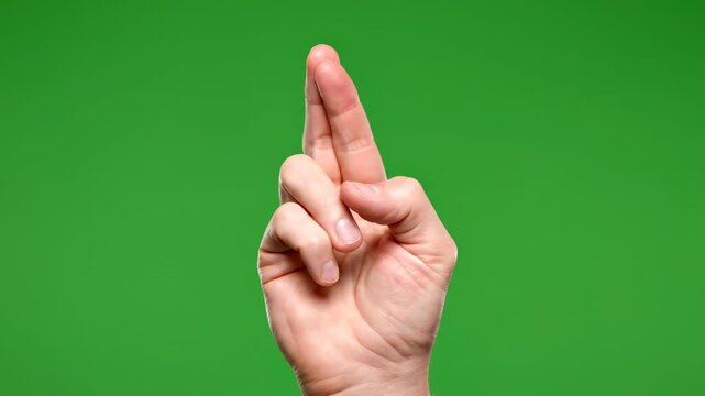 Hand gesture showing fingers crossed for good luck isolated on green screen background