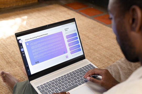 African American man typing on laptop with Digital Marketing Planned Process on rug, copy space
