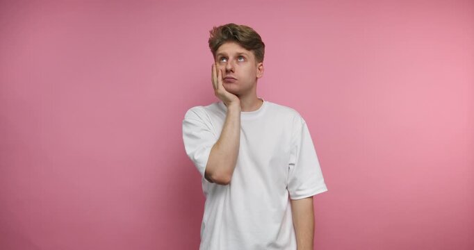 Man shows different facial expressions in front of pink wall during a short time frame