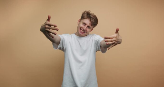 Dance moves and expressions from a young man in a studio setting at daytime with a plain background
