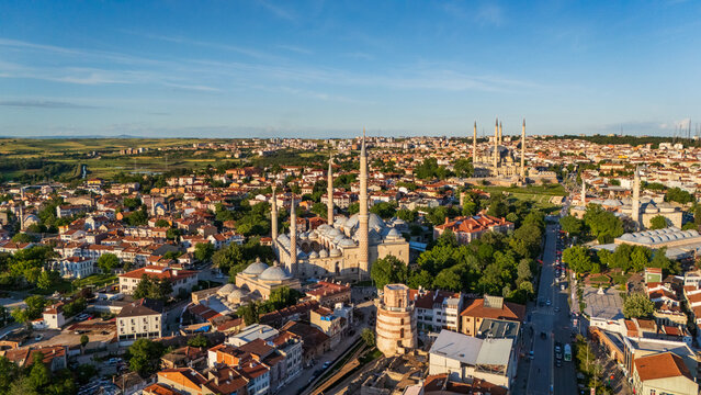 Majestic aerial drone view of Selimiye Mosque in Edirne at sunset, showcasing Mimar Sinan imperial architecture with four high minarets, stone domes and the sprawling city background, Turkey