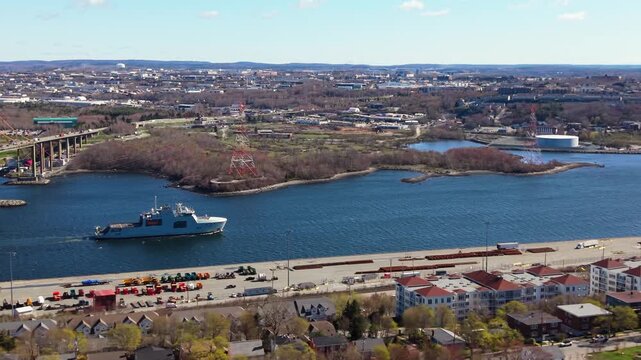 Witness the striking sight of a naval destroyer gliding through Halifax Bay, showcasing the maritime strength and defense capabilities of Canada against a serene sky