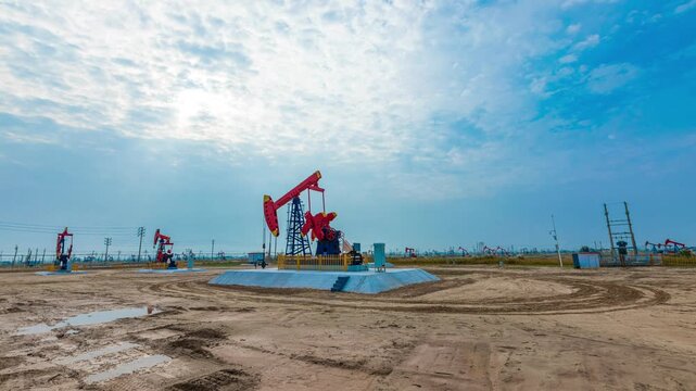 Operating Oil Pumpjacks in Large Onshore Field Under Cloudy Sky