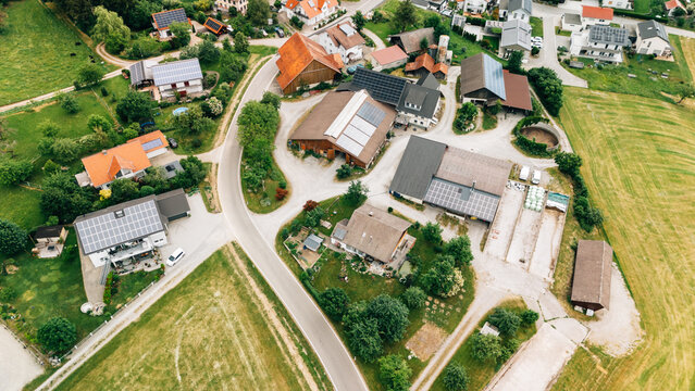 Aerial view of rural village rooftops with solar panels from drone