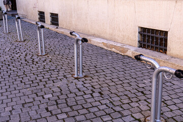 Obraz premium Metal Bicycle Parking Racks on Old Cobblestone Sidewalk