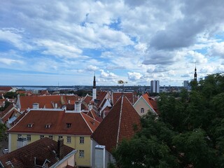 Obraz premium Tallinn skyline shows rooftops and church towers against cloudy sky over Baltic Sea in late afternoon