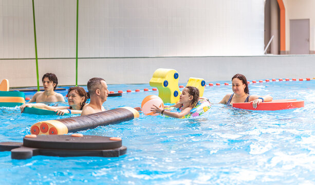 Large group of friends and family playing with pool floats and enjoying time at an indoor water park