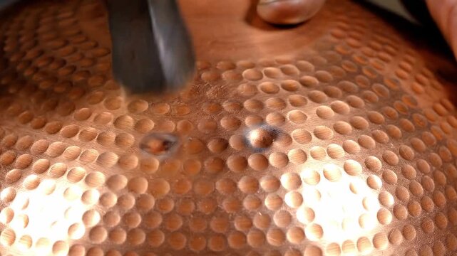 Hammering copper plate with metal tool