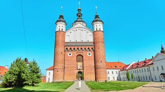 Little beautiful girl walks near Church of Annunciation. Monastery in Suprasl, Podlaskie Voivodeship, North Eastern Poland