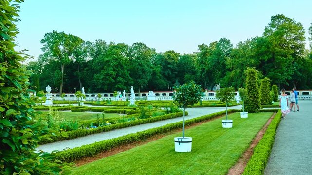 Teen girl walks in park. Branicki Palace is historical edifice in Bialystok, Podlaskie Voivodeship, Poland. It complex with gardens, fountains, pavilions, sculptures, outbuildings and other structures