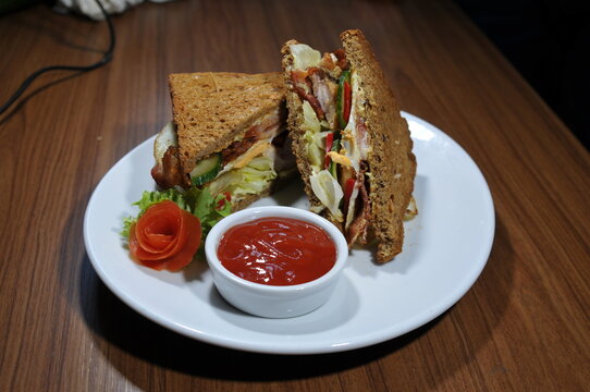 Club-Sandwich mit Pommes, Salat und Dip auf einem Teller. Frisch zubereitete Mahlzeit f&uuml;r Restaurant, Bistro, Caf&eacute; und Gastronomie. Authentisches Echtfoto.