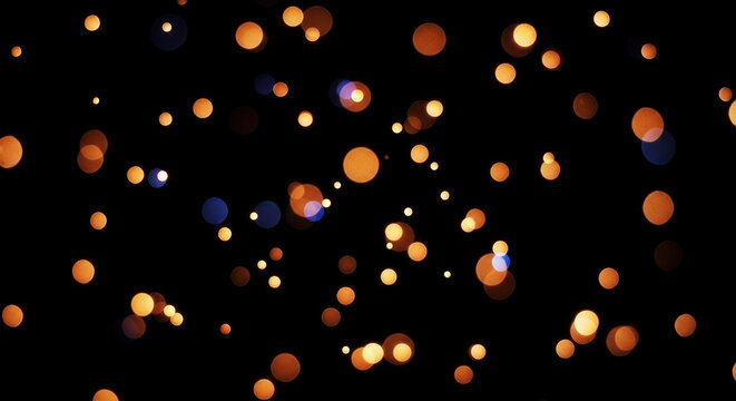 Golden bokeh lights scatter across a dark background. The lights create a dreamy, abstract pattern with varying sizes and colors, primarily shades of orange and yellow.