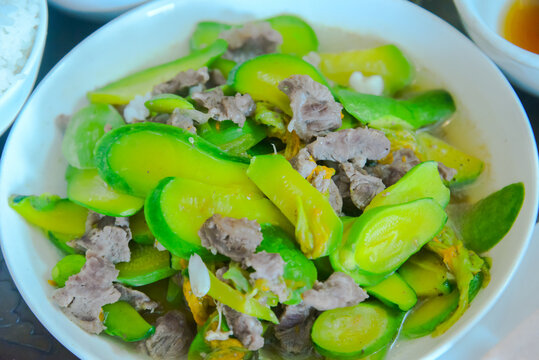 Close-up of buffalo meat and tender squash stir-fry in Vietnam, showing green vegetables, sliced meat, and a simple home-cooked meal.