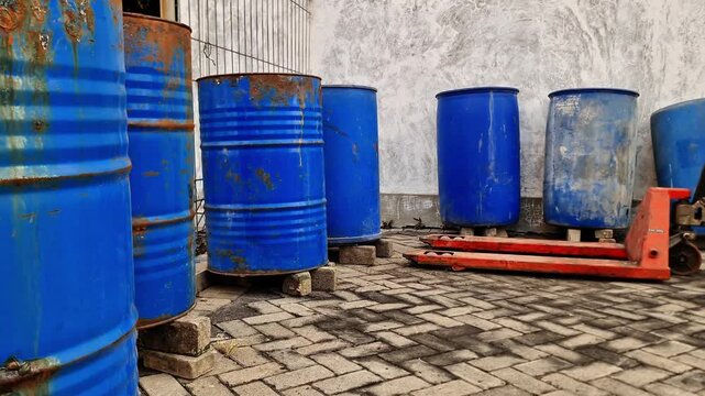 Rows of 200 Liters Blue Steel Drums and Chemical Containers in a Factory Storage Yard