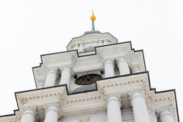 Close up photo of a tall white bell tower rises under overcast winter sky. The Flooded Belfry, Kalyazin, Tver Oblast, Russia. White neoclassical church tower built  in 1796–1800 © evannovostro
