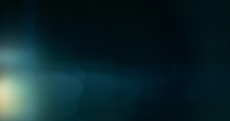 Obraz premium Anamorphic lens flare and light leak effect on dark background. Minimal cinematic optical texture ideal for overlays, film production, motion graphics and visual effects.