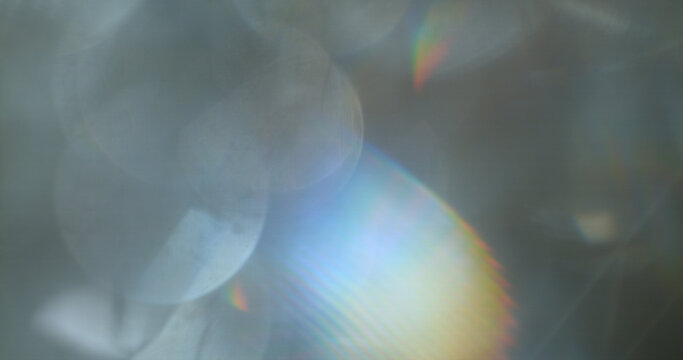 Abstract cinematic lens flare with soft bokeh circles and subtle light reflections. Atmospheric optical effect background ideal for overlays, visual effects, film production and creative design.