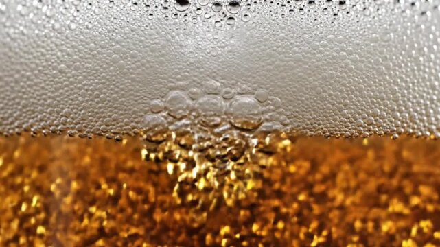 Extreme macro shot of golden beer bubbles and white foam head