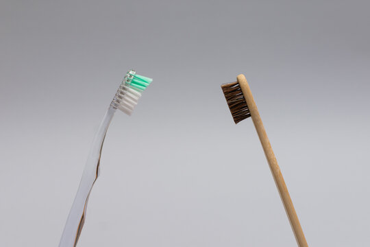 Plastic and bamboo toothbrushes facing each other confrontation eco concept horizontal composition