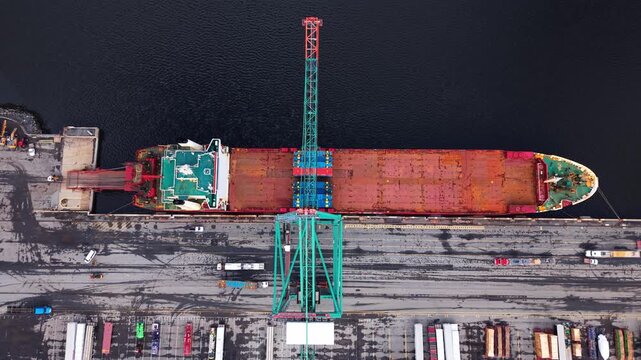 Experience an aerial journey showcasing the busy container port in Nova Scotia, Canada. Witness the colorful ships and cranes orchestrating trade in this bustling hub