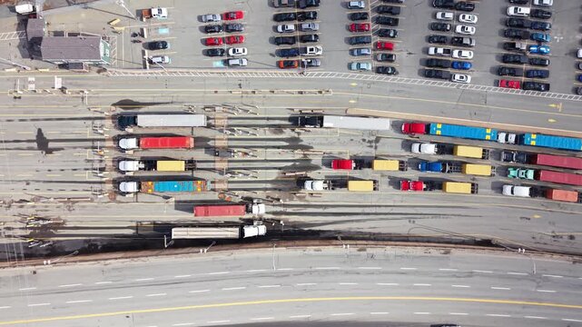 Aerial views capture semi-trailer trucks lined up at Halifax's bustling port, creating a colorful patchwork against the backdrop of waiting cars and busy activity