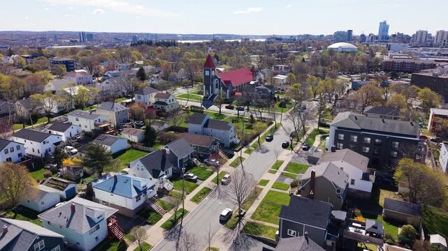 Experience the breathtaking aerial views of St. Stephen Church, highlighting its striking red roof amidst the picturesque landscape of Halifax, Nova Scotia