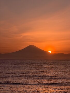 Sunset over ocean with cape silhouette near Mt. Fuji