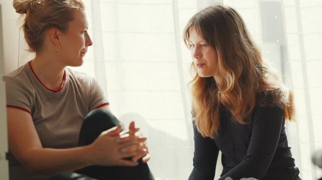 Supportive friend comforting crying young woman