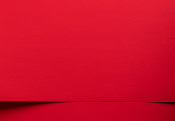 Fototapeta premium Red paper background with a subtle horizontal fold. Minimal textured surface for design, branding, and copy space. Clean abstract backdrop for templates and packaging..