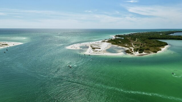 Aerial view of Honeymoon Island State Park featuring pristine white sand beaches, turquoise waters, and lush green vegetation in Dunedin, Florida, United States.
