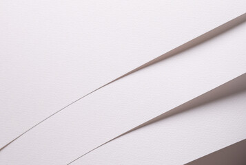 White paper sheets with soft diagonal shadows. Minimal textured stationery background for copy...