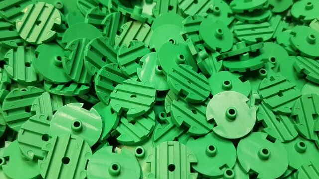 Green plastic parts and components texture background in a manufacturing factory. Industrial synthetic materials production video.