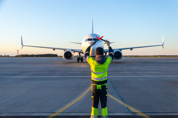 Aircraft marshalling at the aiport. Passenger airplane meeting © Dushlik