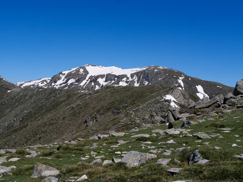 Snow-covered Monte Renoso peak above rocky alpine landscape at Val d'Ese Corsica