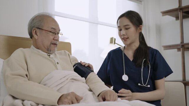 Professional attractive Asian woman nurse cardiologist using blood pressure gauge to examine senior man patient for heart rate to analyze health problem in hospital. Healthcare and medical concept. 