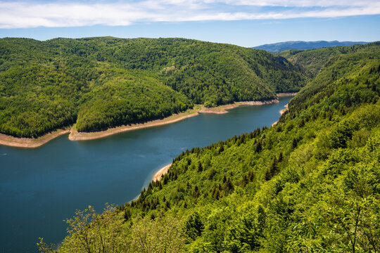 High angle aerial view of the famous Uvac River meanders canyon in Serbia. Stunning drone landscape of curvy river flowing through deep rocky cliffs and green hills.