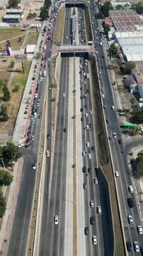 Zapopan, Mexico - February 28 2026: Drone aerial perspective showing a busy highway with multiple lanes of traffic in Zapopan, on a bright sunny day. Cars are moving, creating a dynamic urban scene wi