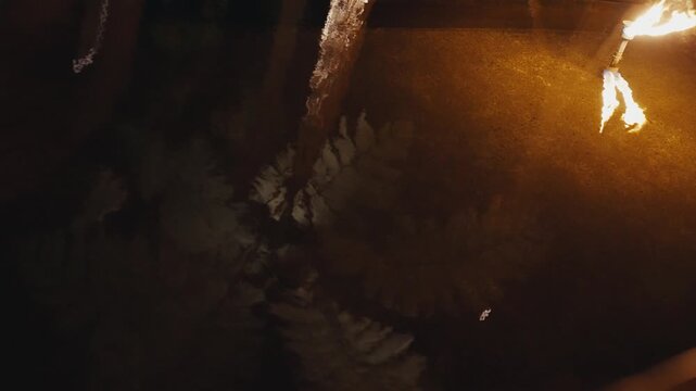 Explorer holding a burning torch in a dark cave