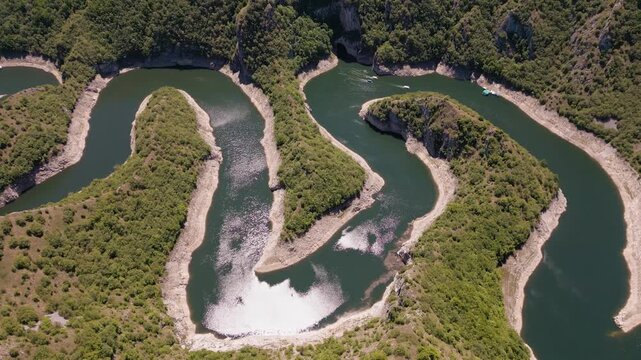 4K cinematic drone shot of the spectacular Uvac River meanders canyon in Serbia. Aerial footage of curvy river winding through deep rocky cliffs and green hills.