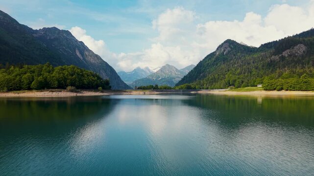 Fast flying over a reservoir lake in the French Pyrenees mountains showcasing the landscape and nature
