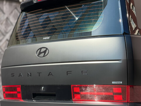 Close-up of a black Hyundai Santa Fe V MX5 logo on a black matte car trunk lid, representing the South Korean automotive industry. Hyundai logo on the trunk lid in mate PPF. Car wrapping. 