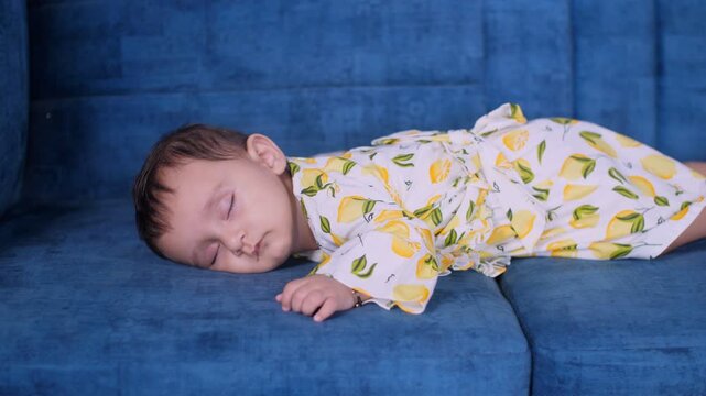Portrait of a sweet baby girl in casual clothes sleeping alone in the living room. Cute tired little toddler taking nao on a comfortable couch - playful  innocent  peaceful  untroubled