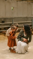 Obraz premium Family bonding with a newborn goat on a rustic farm