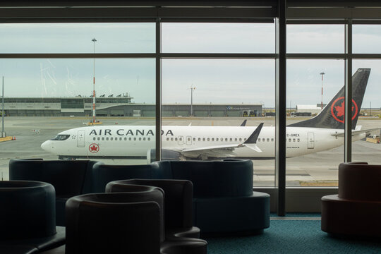 Richmond, BC, Canada - June 13, 2023: A Boeing 737 Max 8 twin-engine jetliner operated by Air Canada is seen taxiing on the tarmac at Vancouver International Airport through terminal building windows.