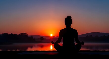 Fototapeta premium Silhouette of a woman practicing yoga and meditation by the lake at sunrise