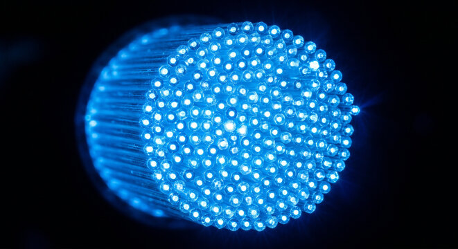 Glowing blue fiber optic cable ends extreme macro on black background