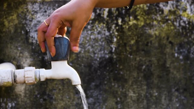 Woman Washing Hands with Running Water During Hot Summer Day in India